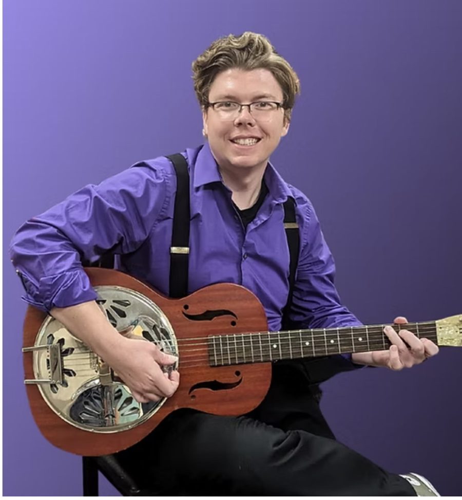 Michael Stickler smiling and playing a resonator guitar